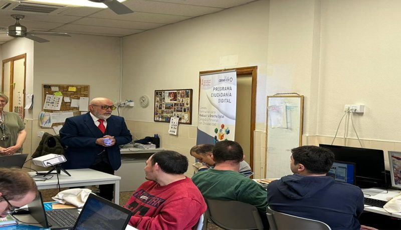 un aula con estudiantes con discapacidad frente ordenadores y les acompaña el pressidente de CERMI CV