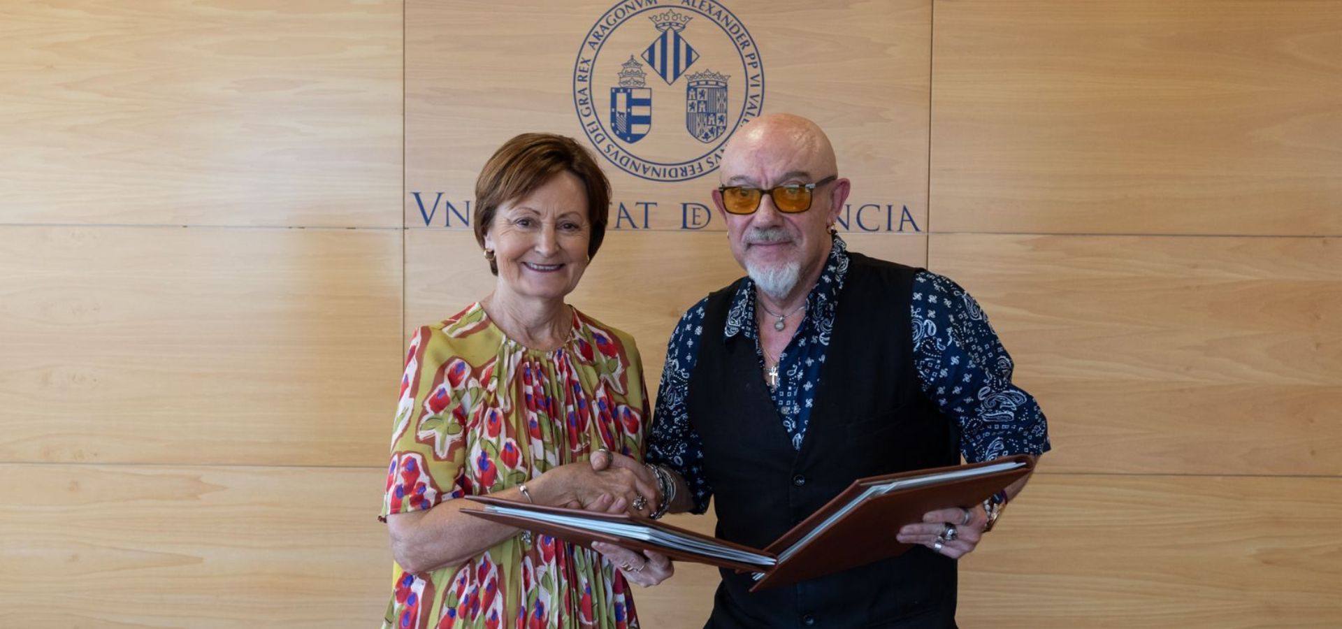 el presidente de CERMI CV, D. Luis Vañó Gisbert, y la Rectora Magnífica de la Universitat de València, Dª. María Vicenta Mestre Escrivá, entrelazan las manos tras la firma