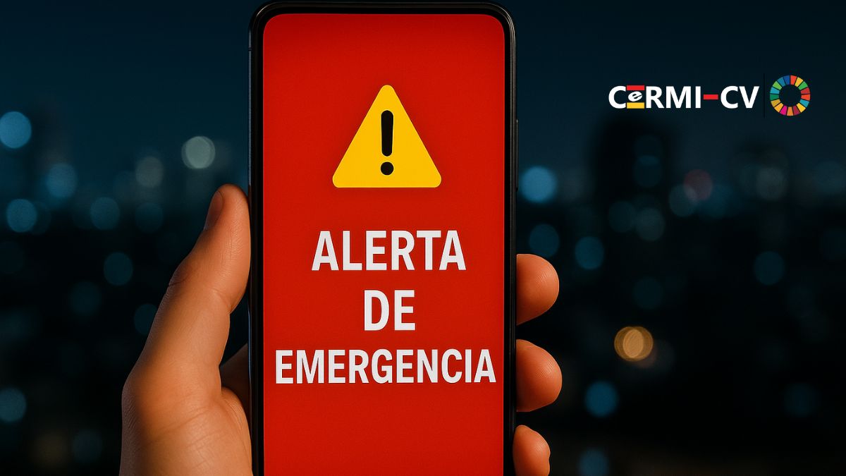 Imagen generada mediante inteligencia artificial: un smartphone muestra una alerta de emergencia en color rojo, con icono de advertencia, sobre un fondo urbano nocturno desenfocado.